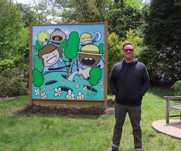 Adam next to his mural