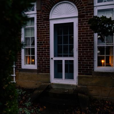 Two candlelights displayed in the windows of the Daweswood House Museum