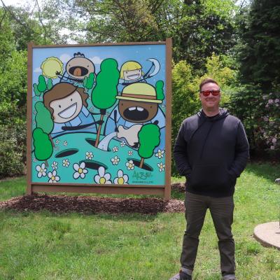 Adam next to his mural